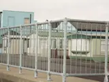 pedestrian handrail system fitted on beach front town with holiday home caravans behind